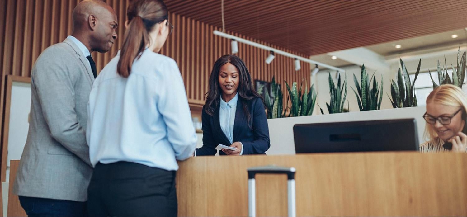 Dubai hotel receptionist assisting guests at a modern front desk